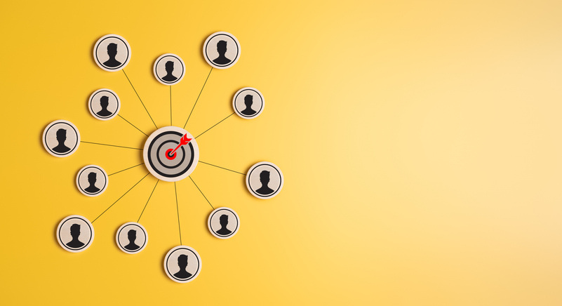 Human icons connected to target icon in the center of the circle on yellow background. Target customer customer and buyer relationship concpet